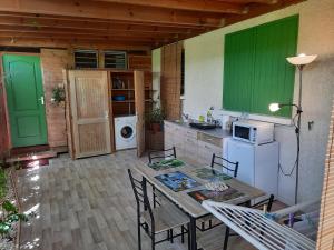 - une cuisine avec des portes vertes, une table et des chaises dans l'établissement Heliconia 1 ou 2 chambres, cuisine, terrasse, piscine partagée, 2 à 4 personnes, à L'Étang-Salé