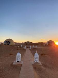 a desert with domes and a sunset in the background at Sunrise Sahara Camp in Merzouga