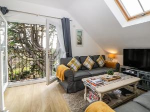 a living room with a couch and a tv at Monterey Mews in Torquay