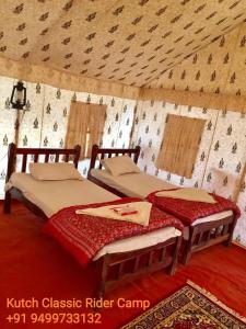two beds in a yurt with a ceiling at Kutch Classic Resort Camp in Dhordo