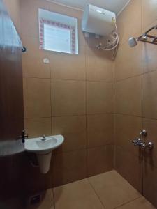 a bathroom with a sink and a shower and a window at Srirengavilasam Elite - Srirangam in Tiruchchirāppalli