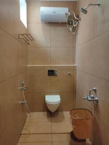 a small bathroom with a toilet and a shower at Srirengavilasam Elite - Srirangam in Tiruchchirāppalli