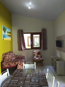 ein Wohnzimmer mit einem Tisch und einem Sofa in der Unterkunft Casa em PIPA 2 quartos 103 in Pipa