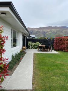 a backyard with a picnic table and a house at 1 - Delightfully fresh, private home close to town in Wanaka