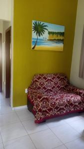 Bett in einem Zimmer mit einer Palme an der Wand in der Unterkunft Casa em PIPA 2 quartos 103 in Pipa