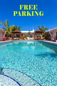una piscina con un cartello che indica il parcheggio gratuito di Green Seas Motel a Hollywood