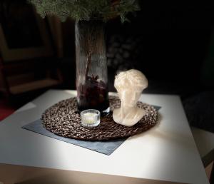 a vase and a statue on a table with a vase at Zhe·Yi Boutique Guesthouse in Beijing