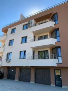 Un grand bâtiment blanc avec un balcon est à votre disposition. dans l'établissement Rowing Base Apartment, à Plovdiv 54 autres photos