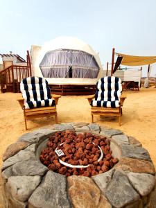 a stone fire pit with two chairs at The Kosmic Tortoise in Twentynine Palms