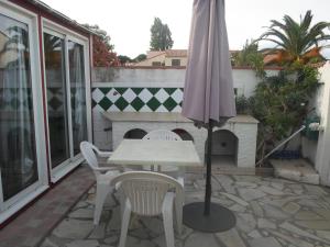 a table and chairs and an umbrella on a patio at coquet f2 avec petite terrasse in Canet-en-Roussillon