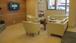 a waiting room with chairs and a couch and a tv at Cambria in San Carlos de Bariloche