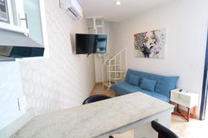 a living room with a blue couch and a tv at Departamento Ibiza in La Paz