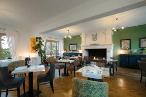 Logis Hotel Le Blason de Provence في مونتيو: غرفة طعام مع طاولات وكراسي ومدفأة