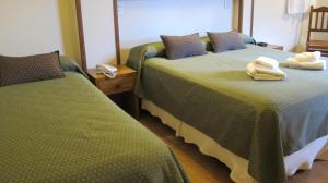 two beds sitting next to each other in a room at Cambria in San Carlos de Bariloche
