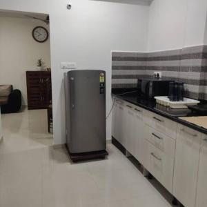 a kitchen with a refrigerator in the middle of a room at Kivi's kozy 2bhk luxurious apartment Goa by leela homes in Arpora