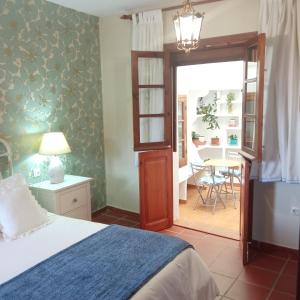 a bedroom with a bed and a room with a table at Lovely Town House Casa La Senda in Grazalema