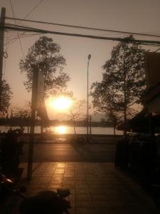 a sunset over a street with trees in the background at TWIN HOME Guesthouse in Kampot