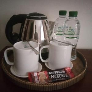 una cesta con tazas y botellas de agua en una mesa en TWIN HOME Guesthouse, en Kampot