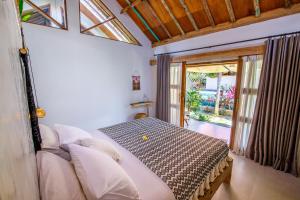 a bedroom with a bed and a table in a room at Seaside Tribe - Boutique Surf Stay & Retreat in Tanah Lot