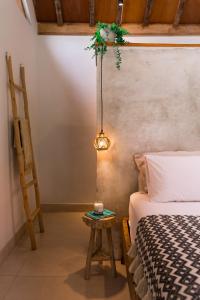 a bedroom with a bed and a table with a lamp at Seaside Tribe - Boutique Surf Stay & Retreat in Tanah Lot