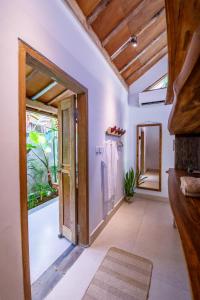 une porte ouverte donnant sur une salle de bains avec une fenêtre. dans l'établissement Seaside Tribe - Boutique Surf Stay & Retreat, à Tanah Lot