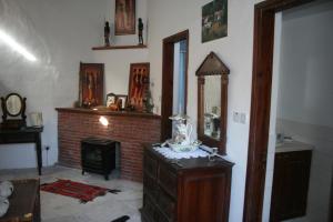 Zimmer mit einem Kamin und einer Kommode mit einem Spiegel in der Unterkunft The Spidaki in Lania