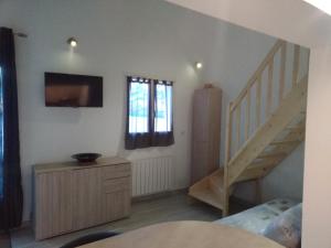 a living room with a staircase and a stair case at Studio Faillant Lorgues spa privatif avec superbe piscine in Lorgues