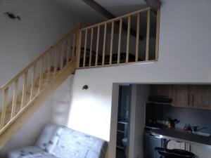 a staircase in a room with a couch and a kitchen at Studio Faillant Lorgues spa privatif avec superbe piscine in Lorgues