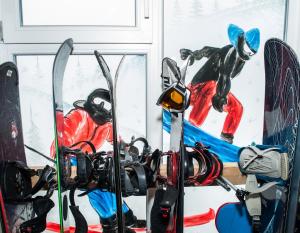 un grupo de esquís y tablas de snowboard en una habitación en Good House en Slavske
