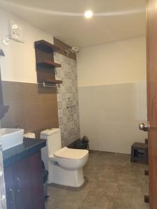 a bathroom with a toilet and a sink at Chique Shanti Resort in Mandrem