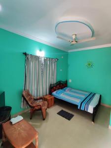 a bedroom with a bed and a table and a chair at DG House in Patnem