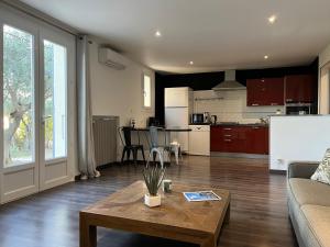 een woonkamer met een salontafel en een keuken bij Villa Coris in Draguignan