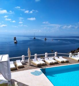 a large swimming pool with a yacht in the distance at Hotel La Piazza in Panarea