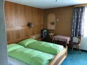 a bedroom with a bed with green pillows and a table at Villa Ilse in Kappl