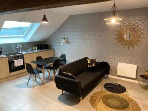 uma sala de estar com um sofá e uma mesa em APPARTEMENT CHALEUREUX Wifi et parking gratuit em Givet