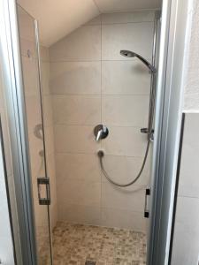 a shower with a glass door in a bathroom at Ferienwohnung Jubiläumsgrat in Grainau