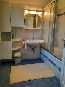 a bathroom with a sink and a tub and a mirror at Haus Grünwald in Gosau +46 photos