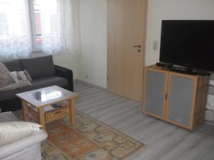 a living room with a flat screen tv on a cabinet at Drahtesel Oase in Pömmelte