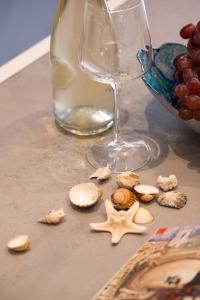 een tafel met schelpen en een wijnglas en een kom druiven bij 60mt dal mare in Viareggio