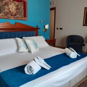 una camera da letto con un letto e asciugamani di D'Angelo Palace Hotel a Mazara del Vallo
