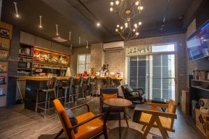 un bar en un restaurante con mesas y sillas en 雅舍 Arthur Hostel en Jinning