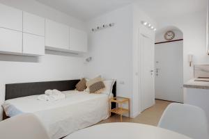 Habitación blanca con 2 camas y cocina en Wonderful studio in Pta romana 10 mins from Duomo by Easylife, en Milán