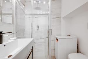 y baño blanco con ducha y aseo. en Wonderful studio in Pta romana 10 mins from Duomo by Easylife, en Milán