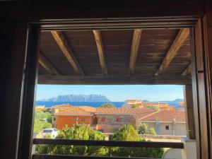 a window with a view of a mountain at Residence Spiaggia Bianca in Golfo Aranci