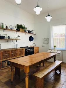 a kitchen with a table, chairs and a microwave at de Wingerd B & B in Graaff-Reinet