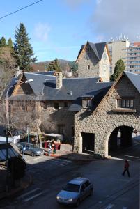 a stone building with a car parked in front of it at Hotel Flamingo in San Carlos de Bariloche