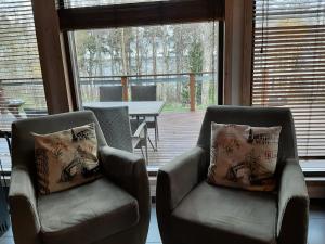 two chairs and a table in a room with a patio at Kiurun Villas in Imatra