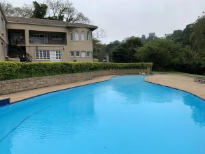 a large blue swimming pool in front of a house at Springside House in Hillcrest