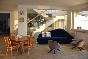 salon z niebieską kanapą, stołem i krzesłami w obiekcie Giuggiulena w Syrakuzach