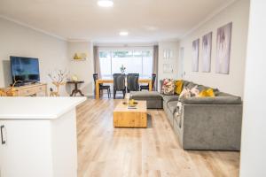 a living room with a couch and a table at Plettenberg Bay Unit 2 Greenpoint Mews Apartment with Backup Power in Plettenberg Bay